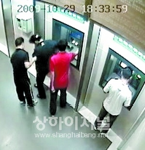 ▲ 여성이 흠칫하는 순간, 붉은 옷을 입은 남성이 재빨리 여성의 카드를 빼내고 가짜은행카드와 바꿔치기 한다.