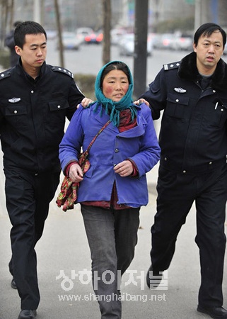 ▲ 어린이를 대동하고 구걸을 하던 여성을 조사하기 위해 경찰서로 연행하고 있다.